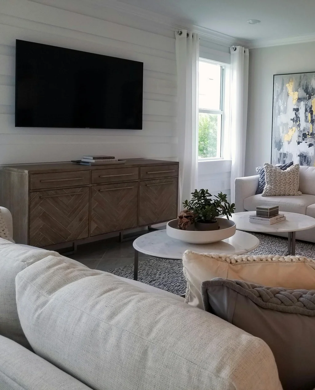 Modern living room with a wall-mounted TV and organized media console